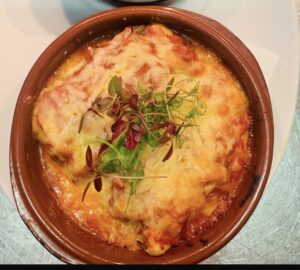 CANNELLONIstuffed with ricotta and spinach in bechameltomato sauce topped with mozzarella. (v)