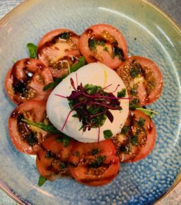 BURRATA CAPRESE Whole mozzarella ball with sliced tomato,basil oil & rocket salad drizzled with balsamic vinegar (VG)